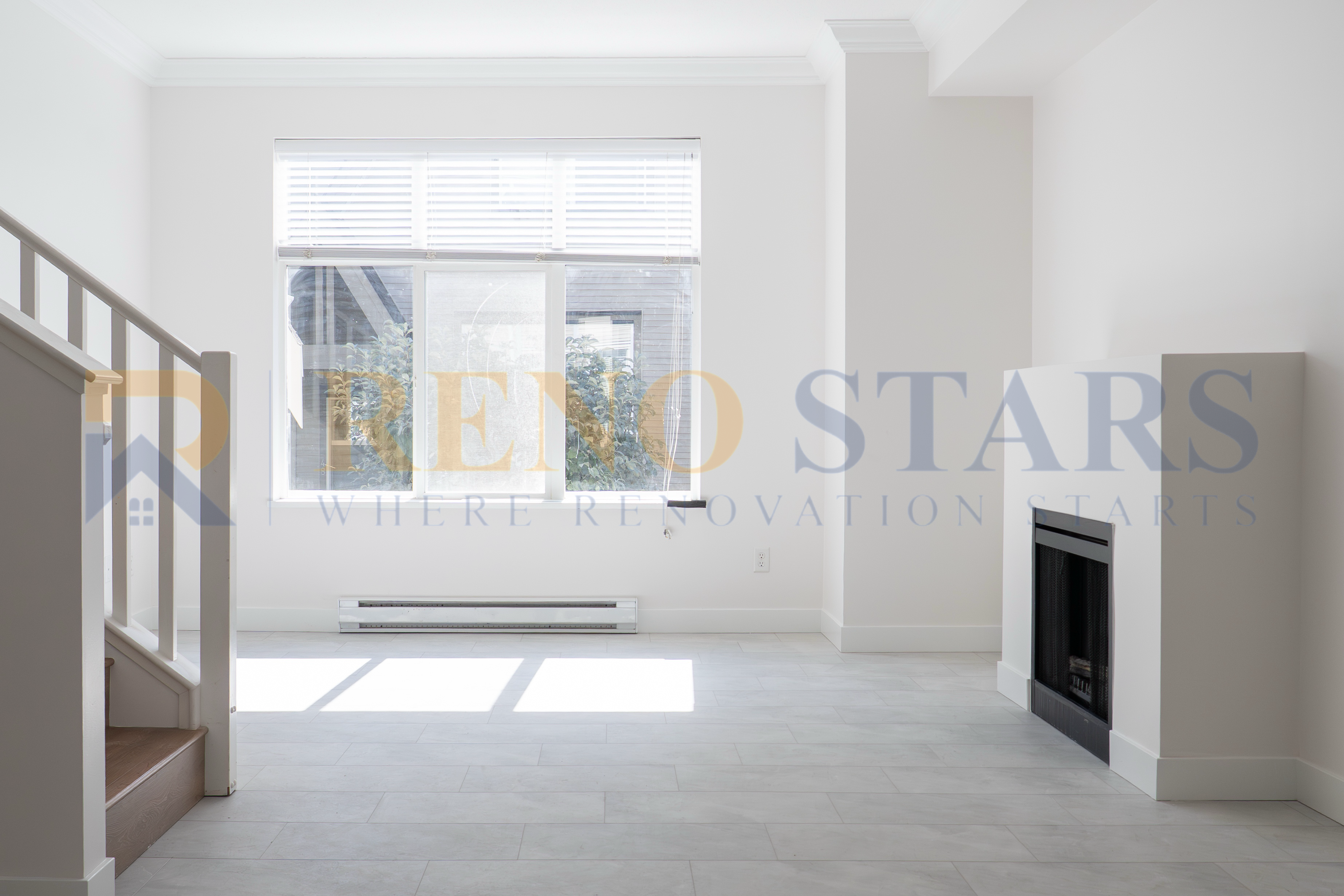 明亮的空客厅，配有大窗户和现代壁炉。