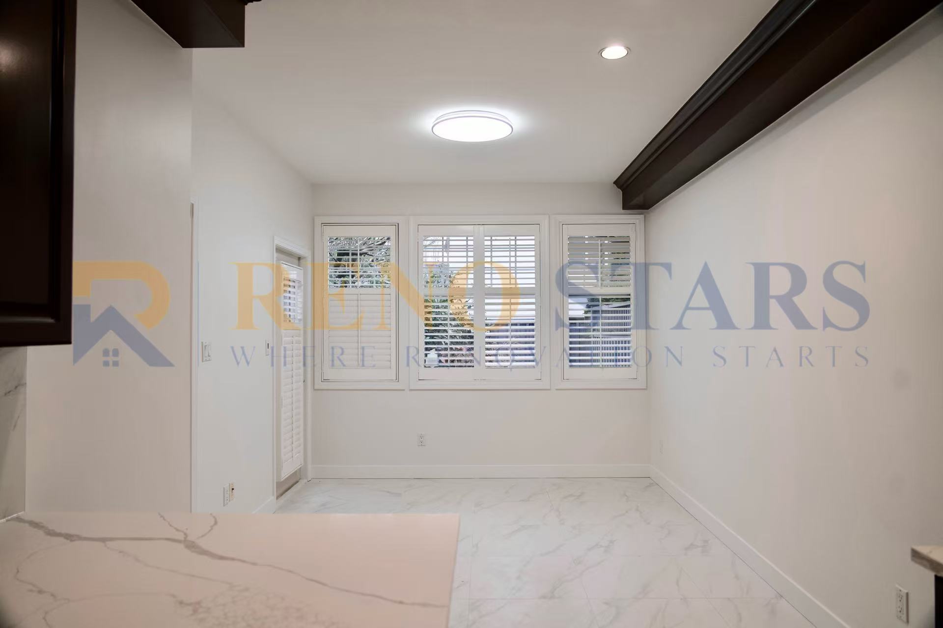 Bright, modern room with white walls, large windows, and marble flooring.