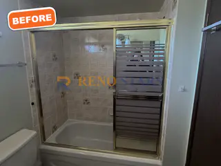 Dated tub with gold-framed sliding door before renovation