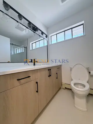 New vanity with modern lighting and matte-black hardware