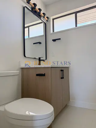 New wood-tone vanity with matte-black fixtures