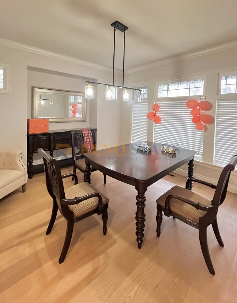 Elegant dining area featuring a wooden table, stylish chairs, and modern lighting.